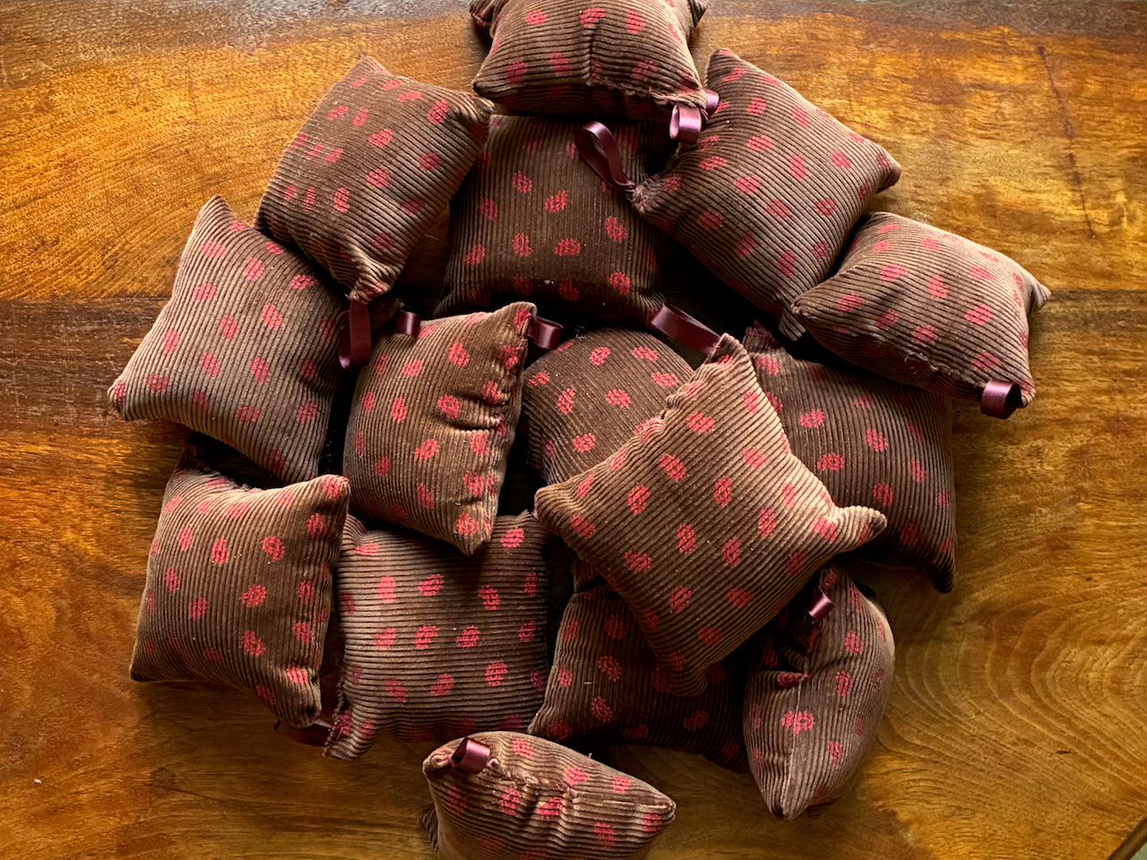 A pile of Chestut and Rose Needlecord Pincushions by Curlew Crafts