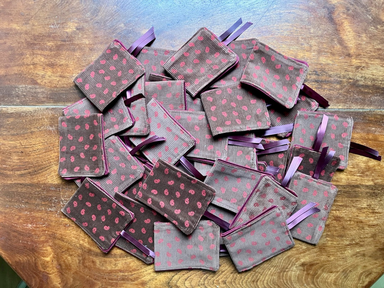 Pile of Brown and Rose Paisley Needle Cases by Curlew Crafts