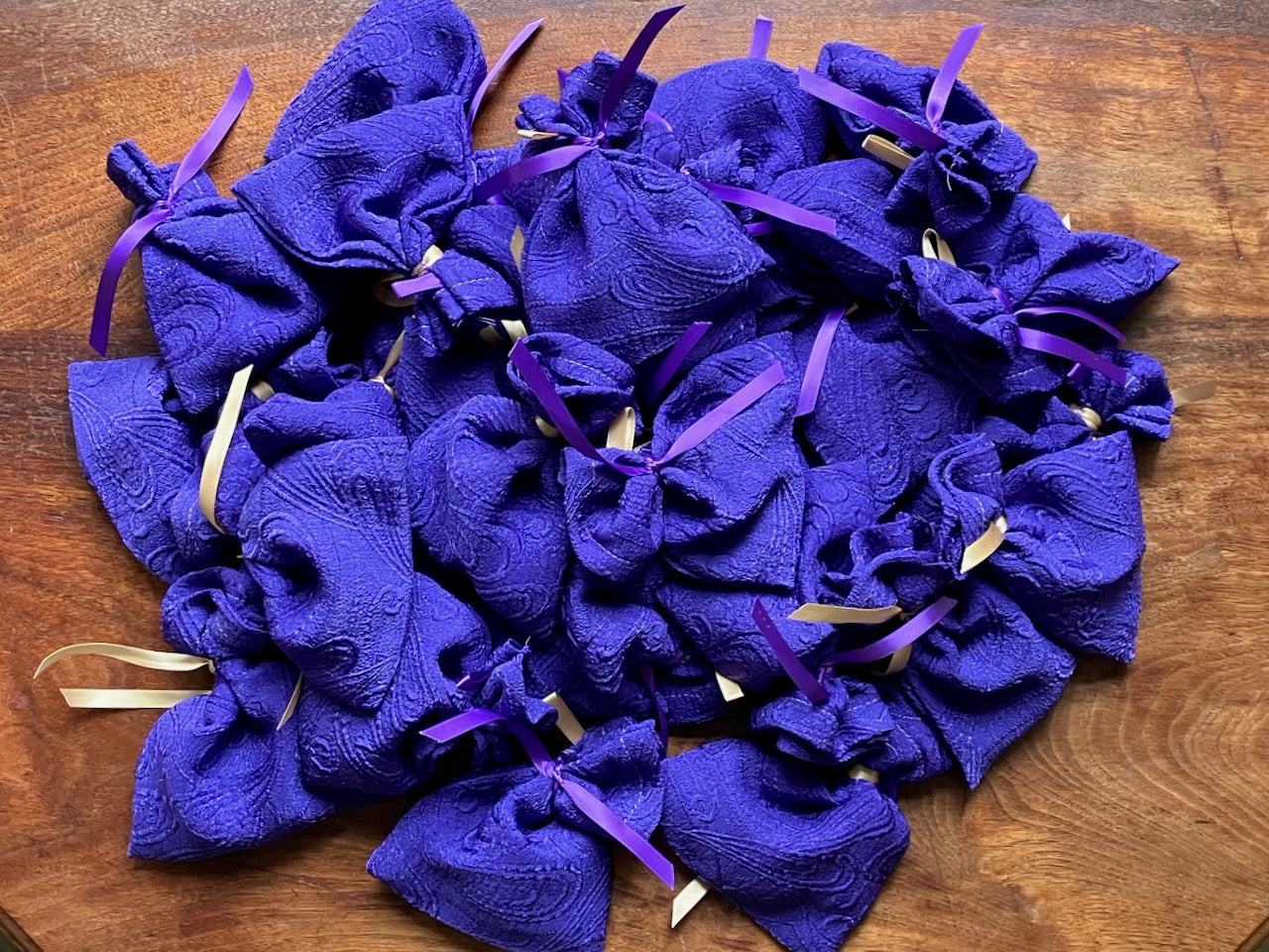 Pile of Purple Lavender Sachets with purple and gold ribbons